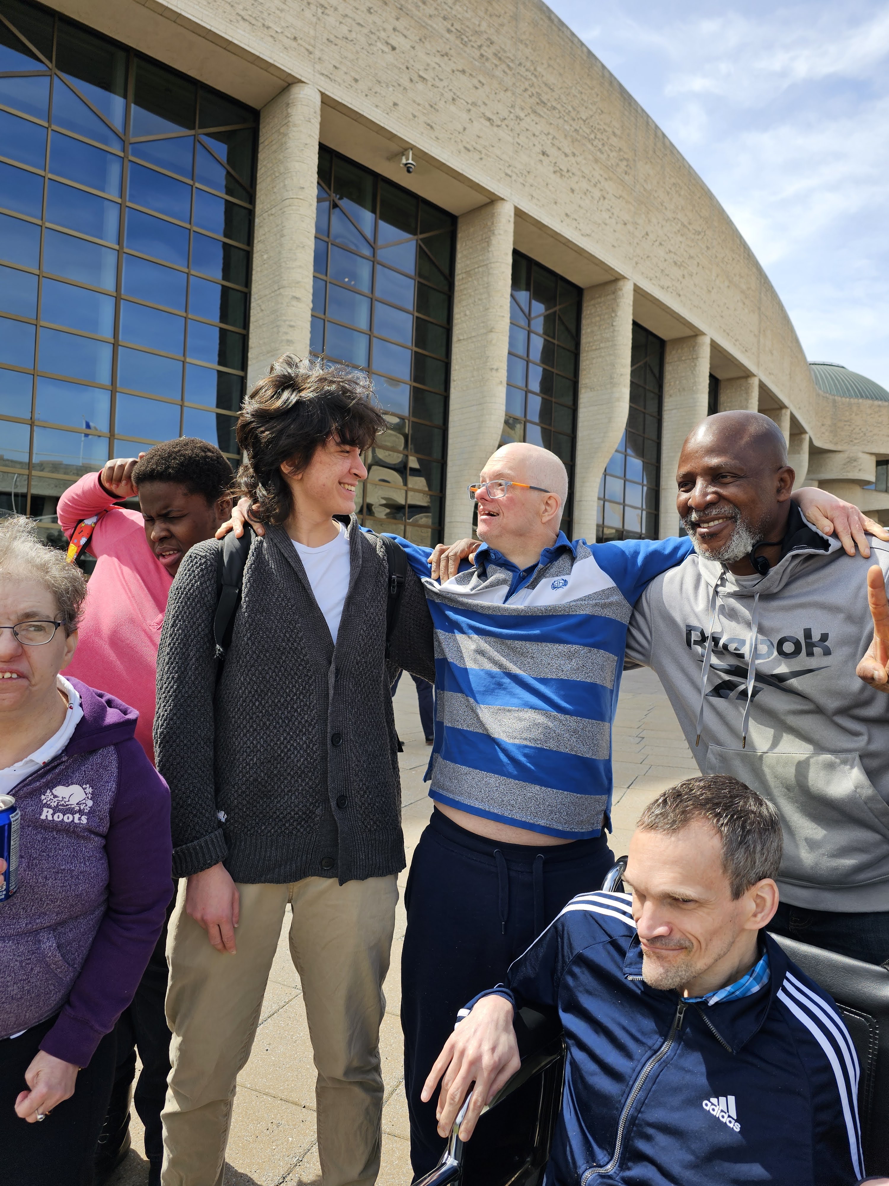 les membres de cœurs avec les assistants en devant d'un bâtiment beige