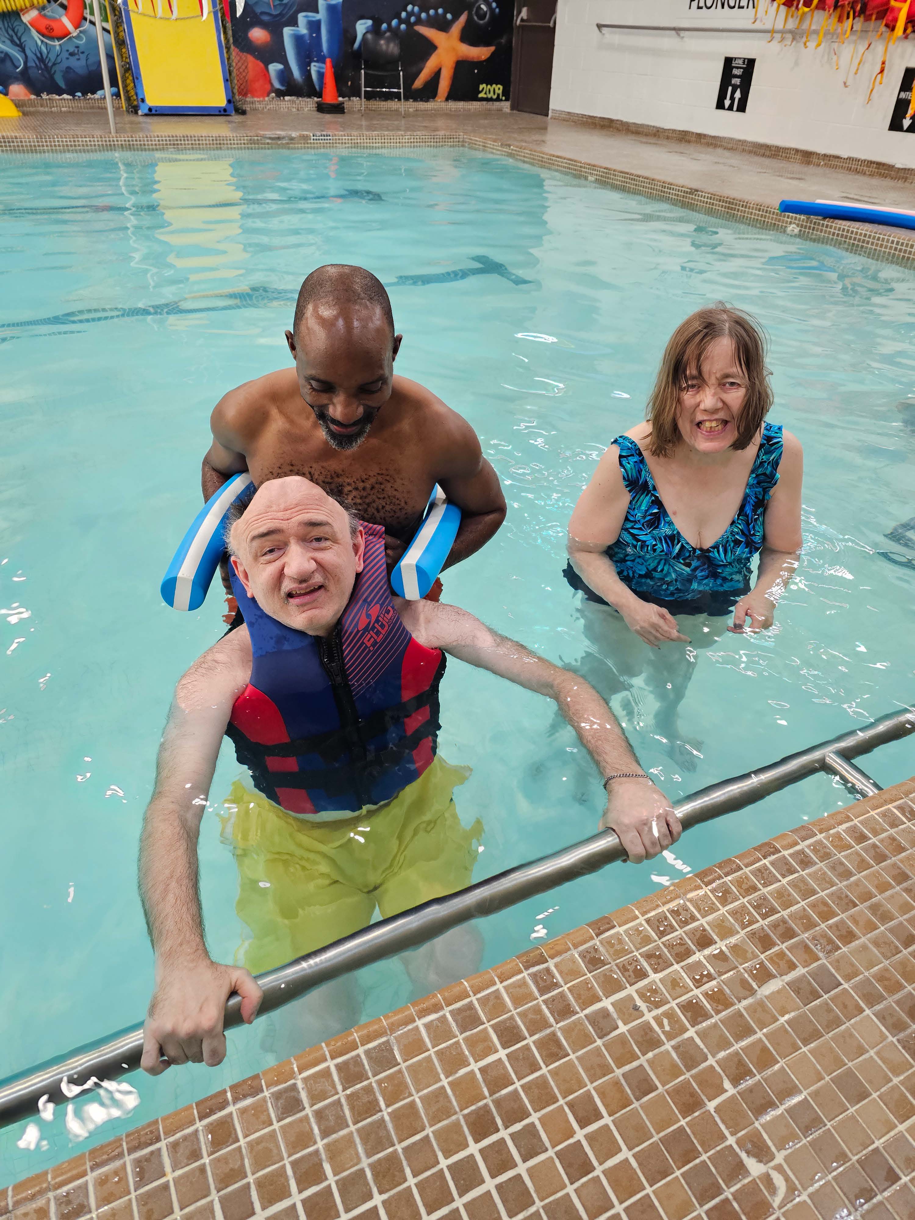 trois personnes est dans un piscine
