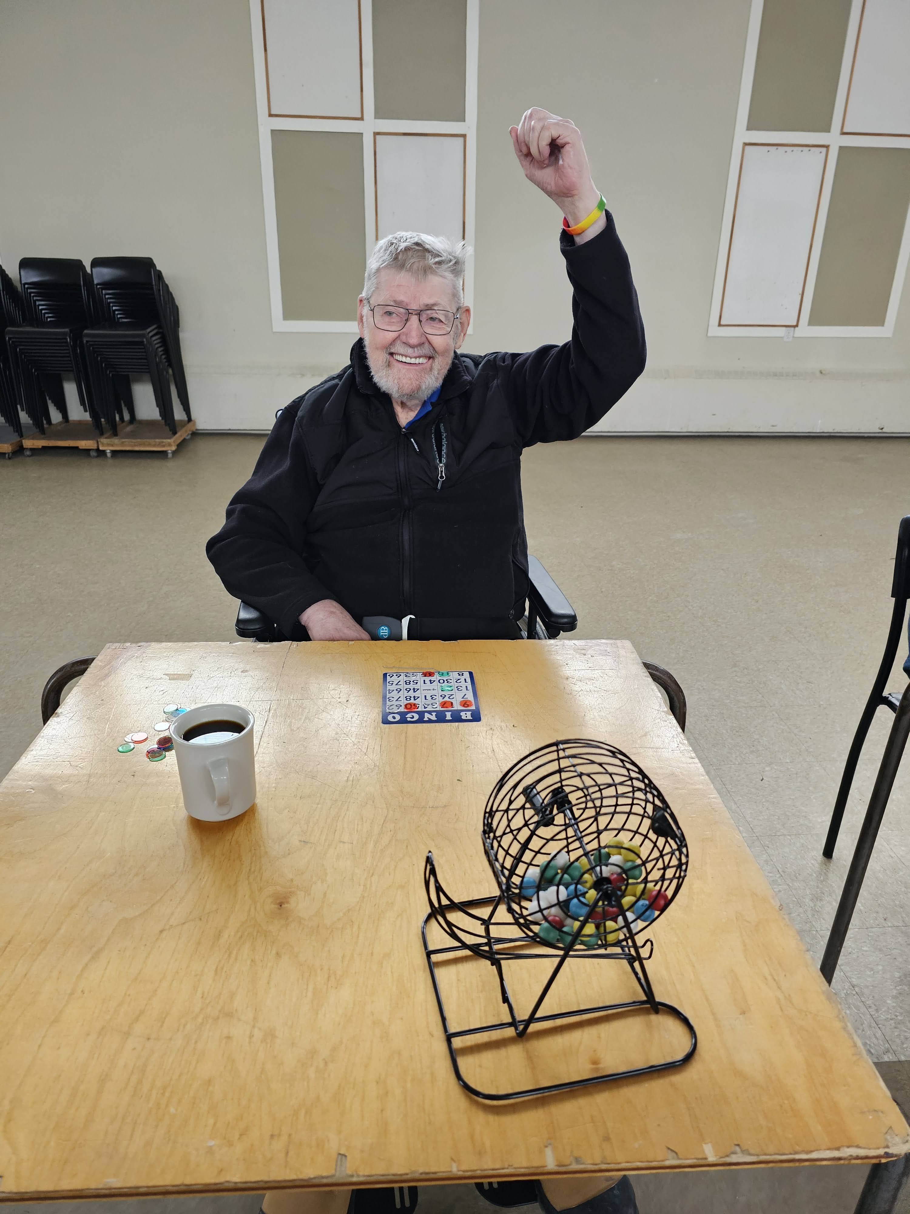 un membre de cœur sourire et lève son main en jouant le bingo