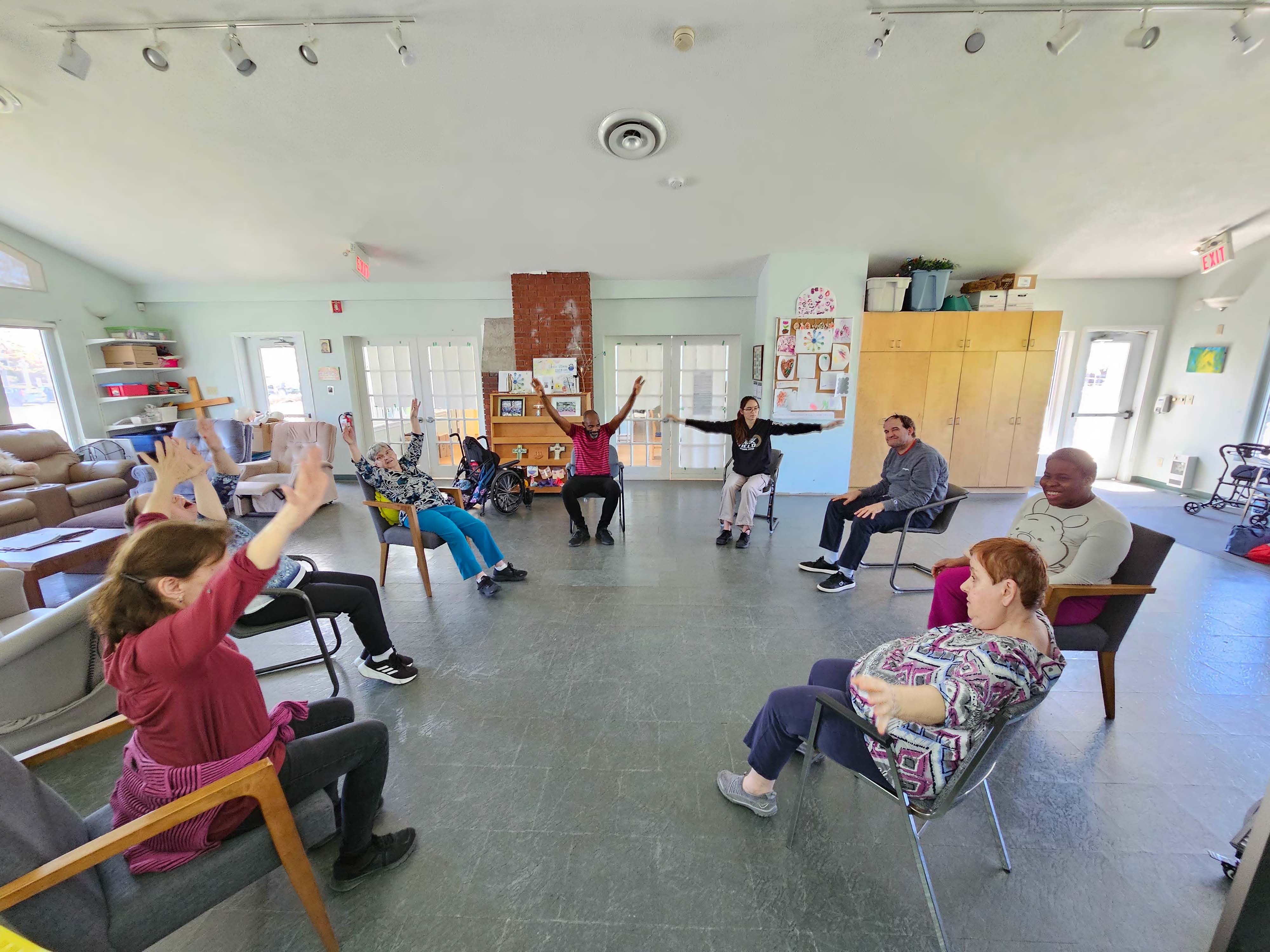 un groupe de personnes assis dans un cercle avec leurs mains dans l'air