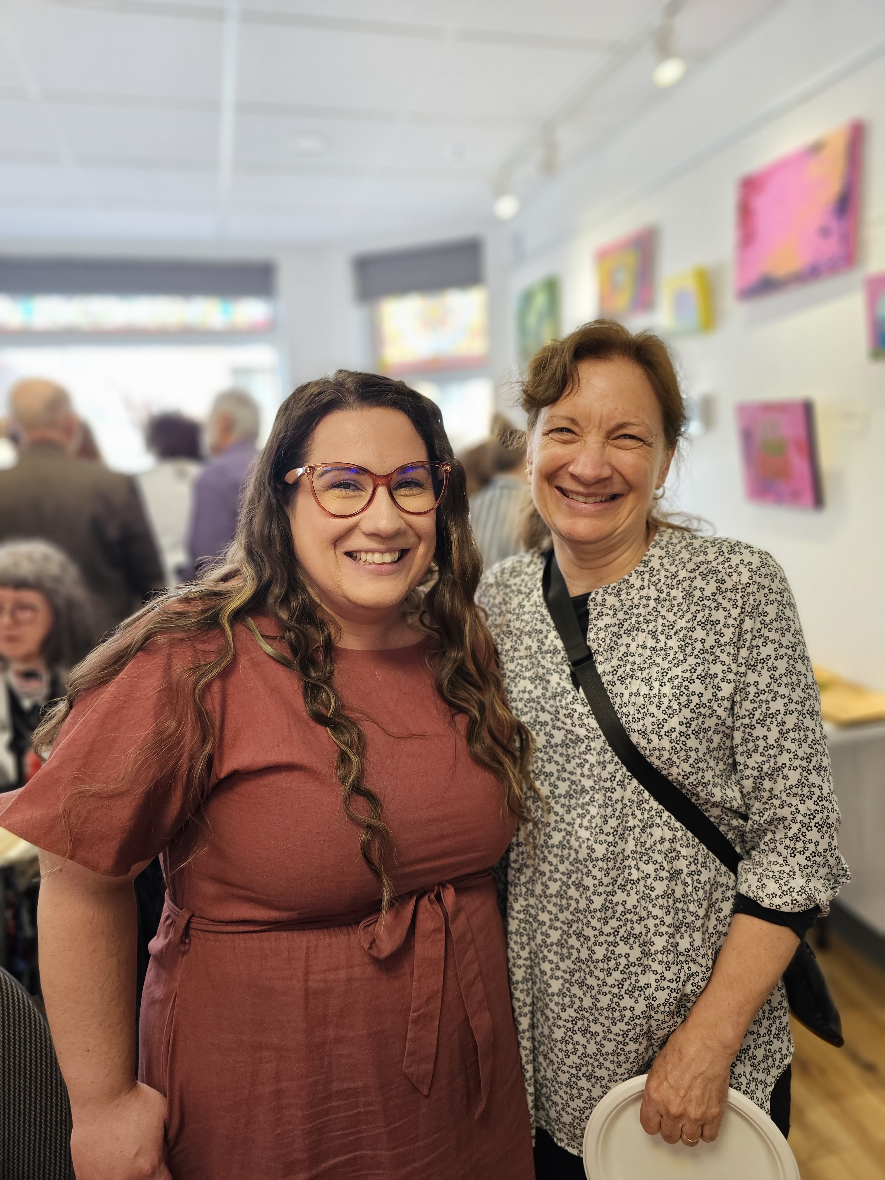 deux femmes posent pour le caméra à un évènement