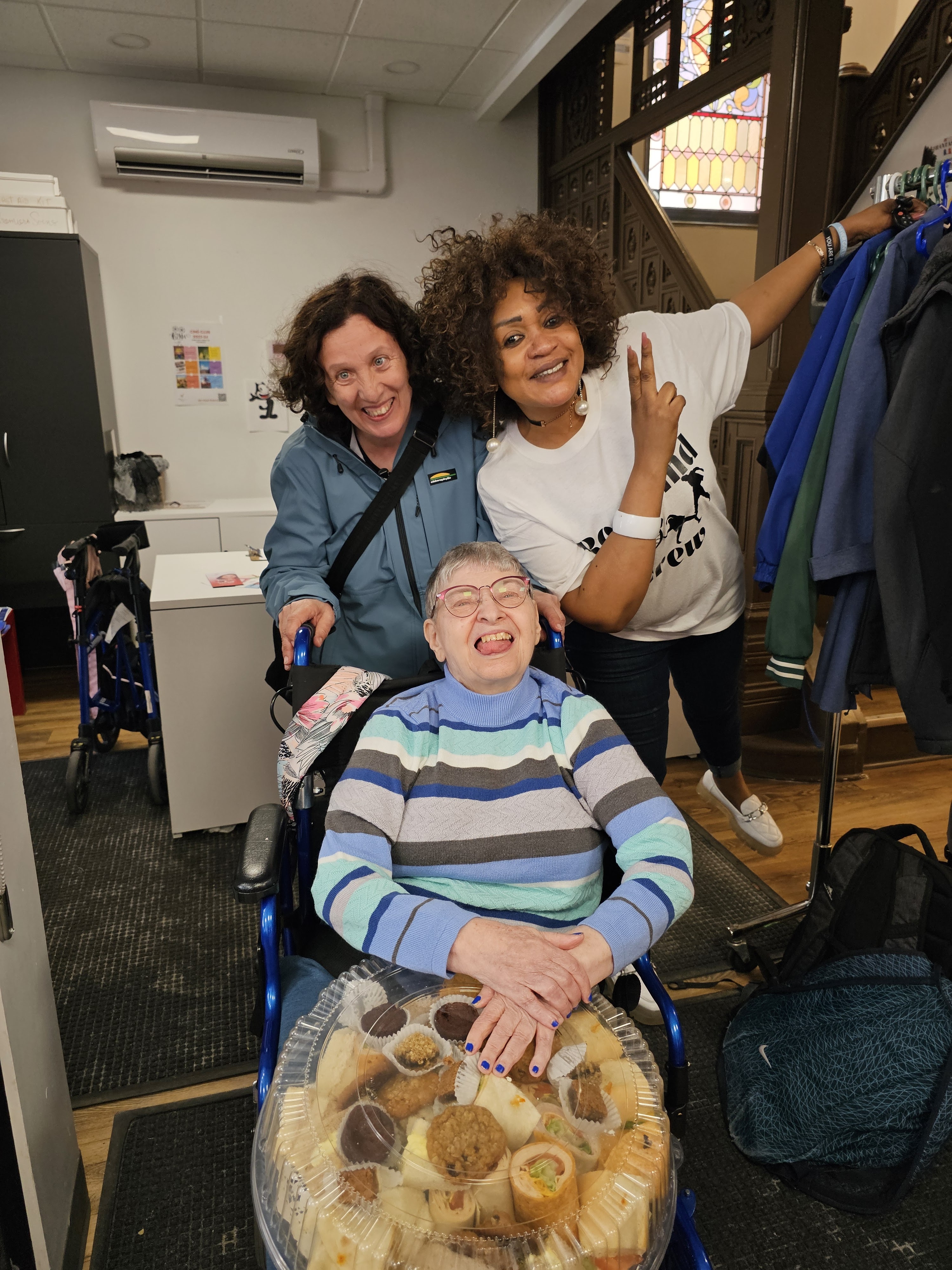 trois personnes posent pour le caméra avec un qui tient un plat de sandwich