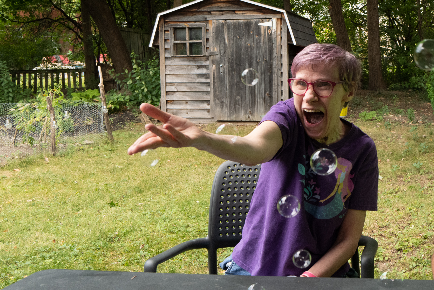 un membre de cœur avec des bulles qui est assis dehors