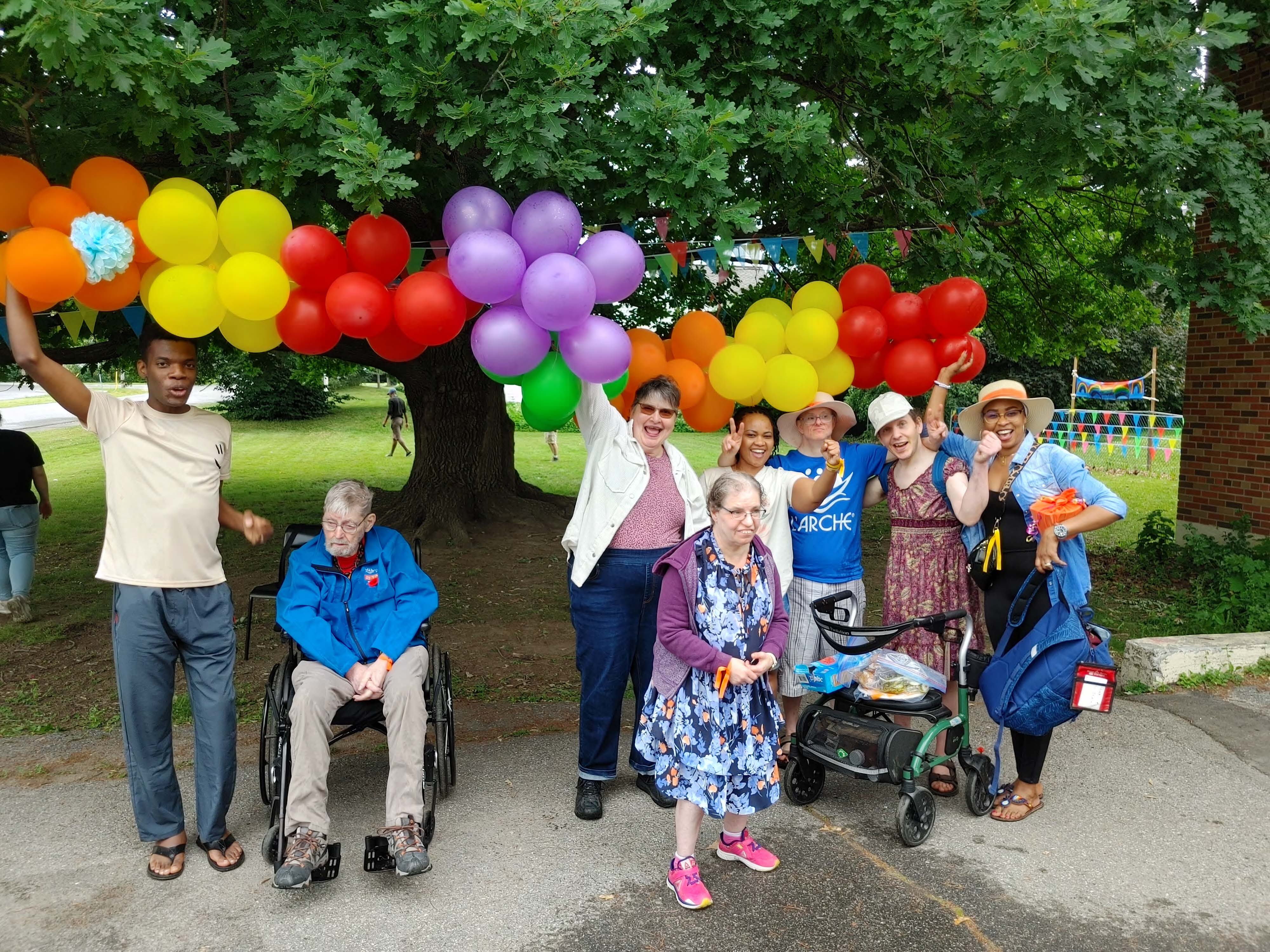 un groupe de personnes posent en devant d'un parc aves les balloons multicoloures