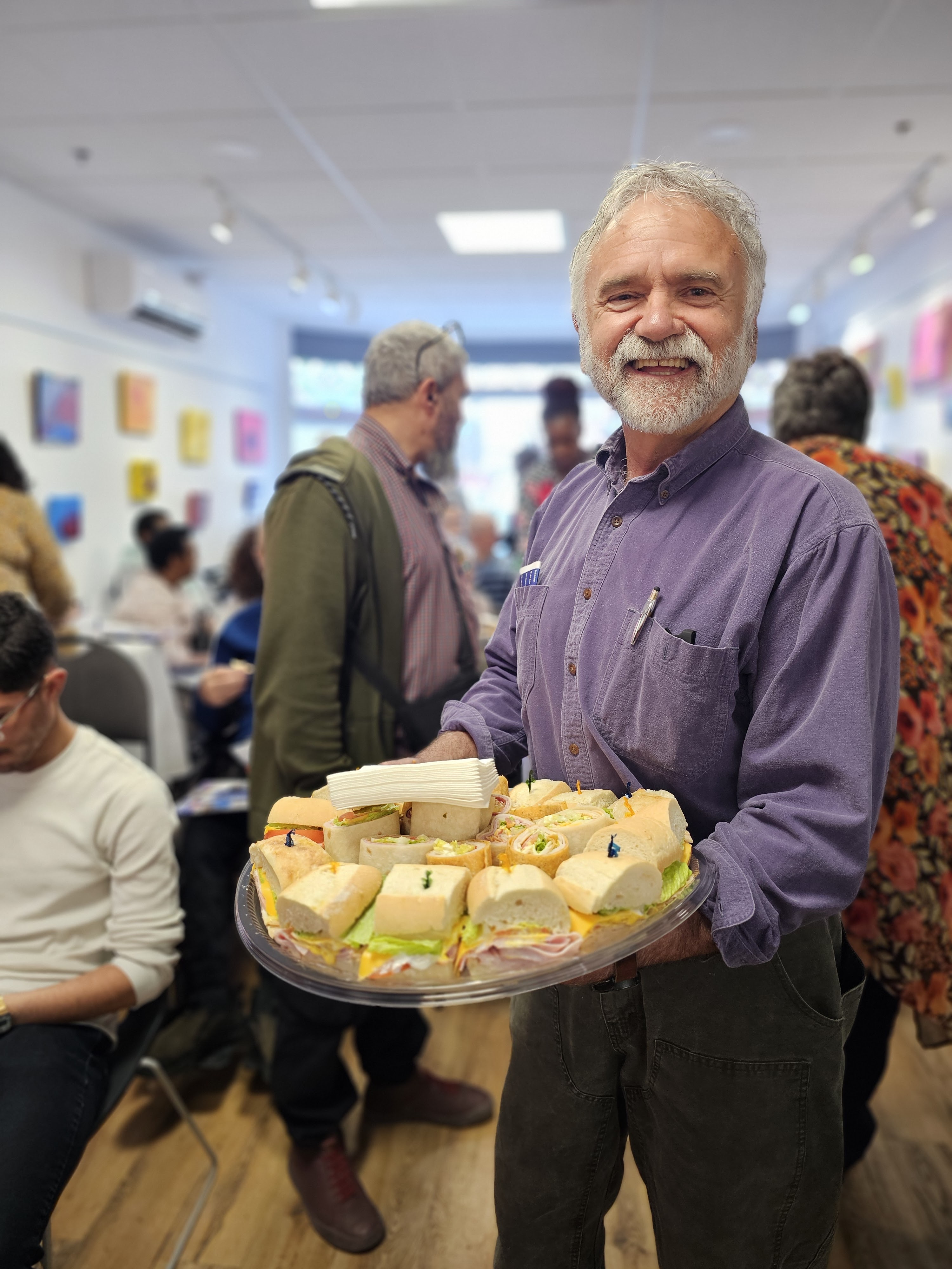 un homme avec un plat de sandwich