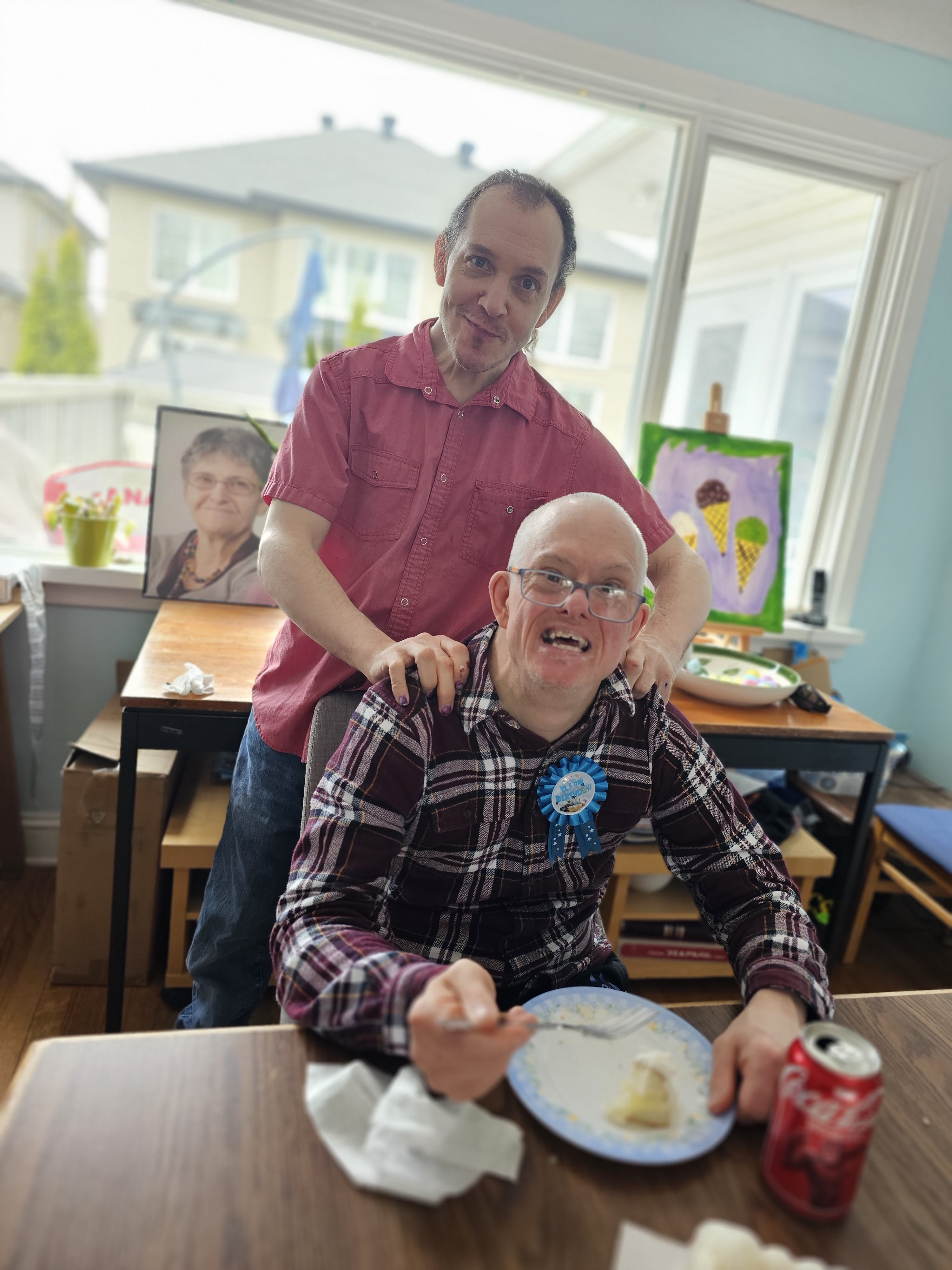 deux membres de cœur posent pour le caméra, un avec qui mange le gâteau