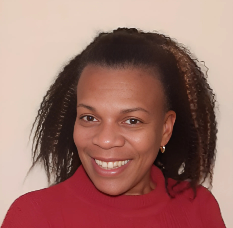 Photo en gros plan d'une femme portant un haut rouge, souriant à l'appareil photo.